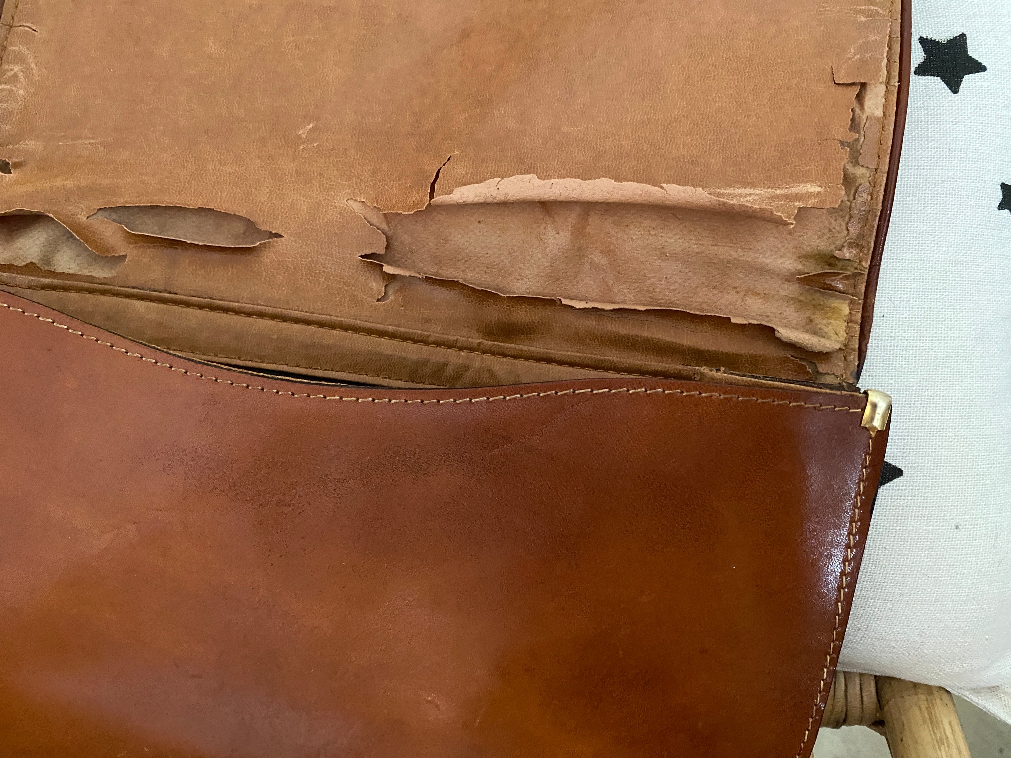 Pochette tout cuir vintage caramel patiné – vue intérieure détail défaut cuir côté droit et détail de finition en métal doré – seconde main