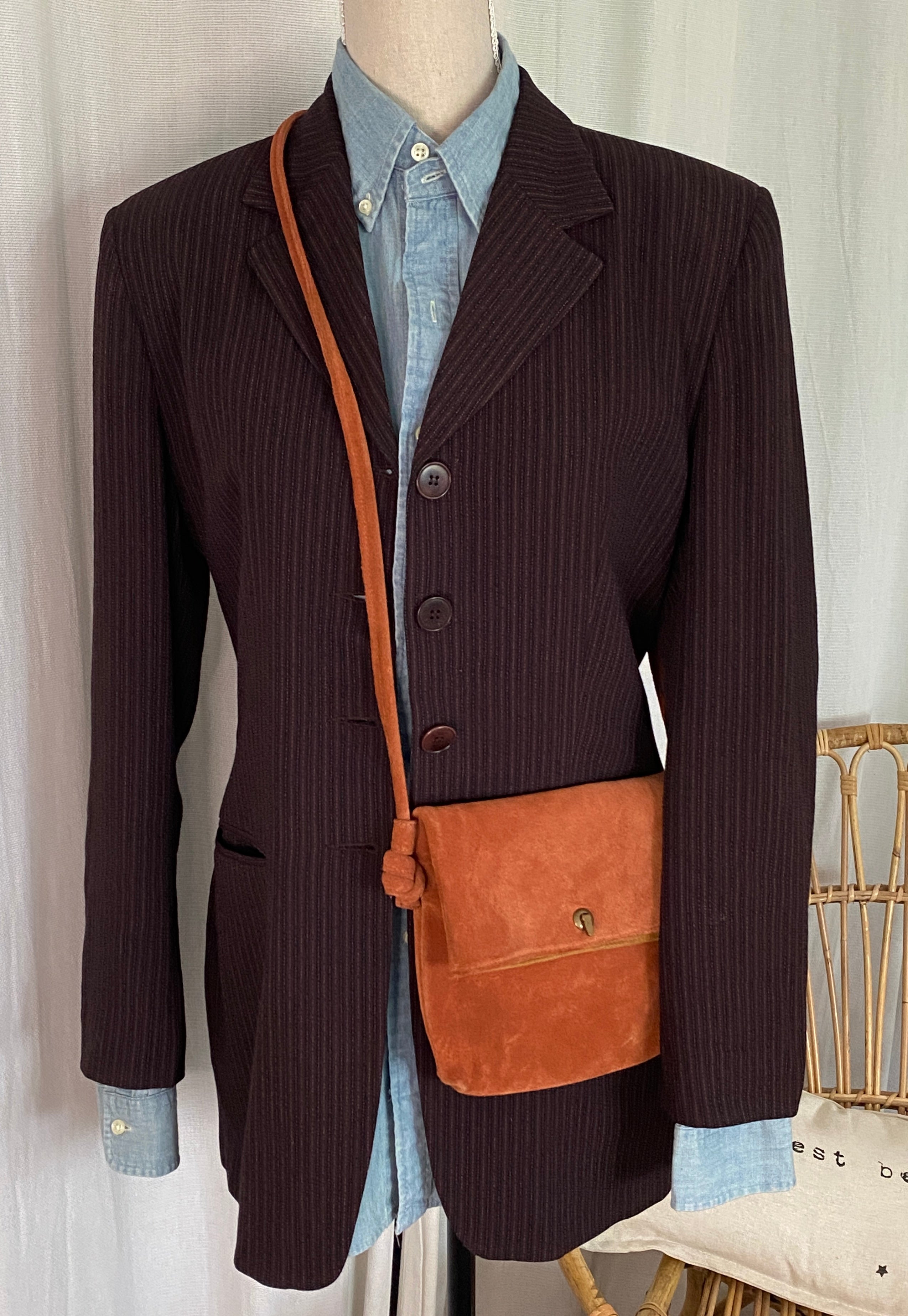 Sac bandoulière daim rouille seconde main – vue de face porté sur blazer rayé pour inspiration