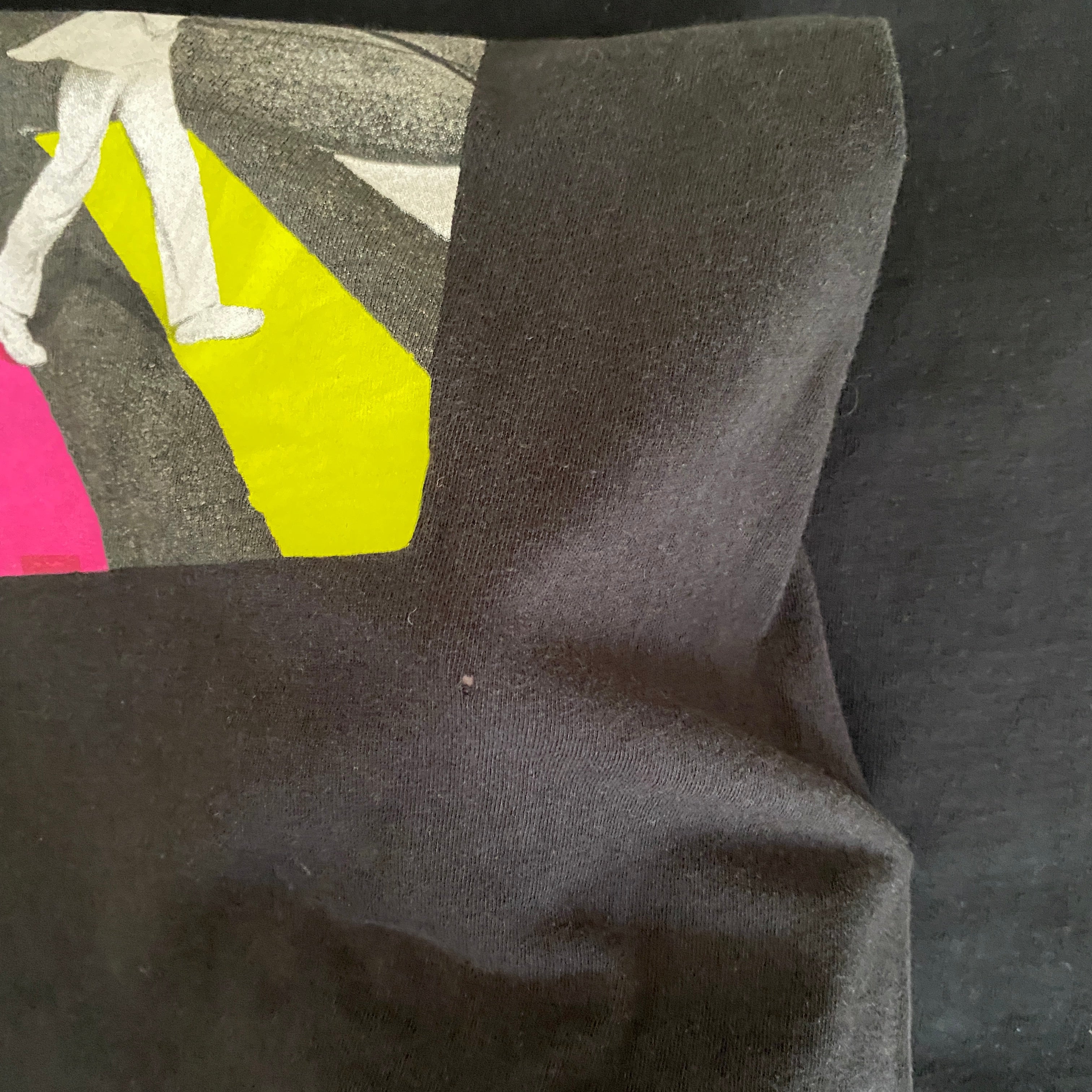 T-shirt officiel The Beatles Abbey Road seconde main – détail mini trou sous angle bande jaune flocage