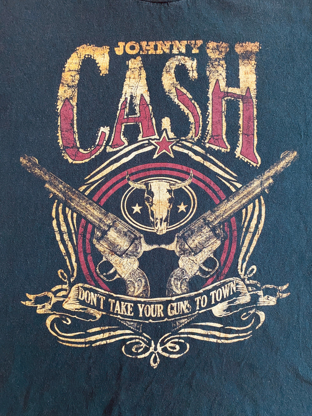 Détail flocage Johnny Cash – revolvers croisés, banderole et lettrage doré – style worn & washed