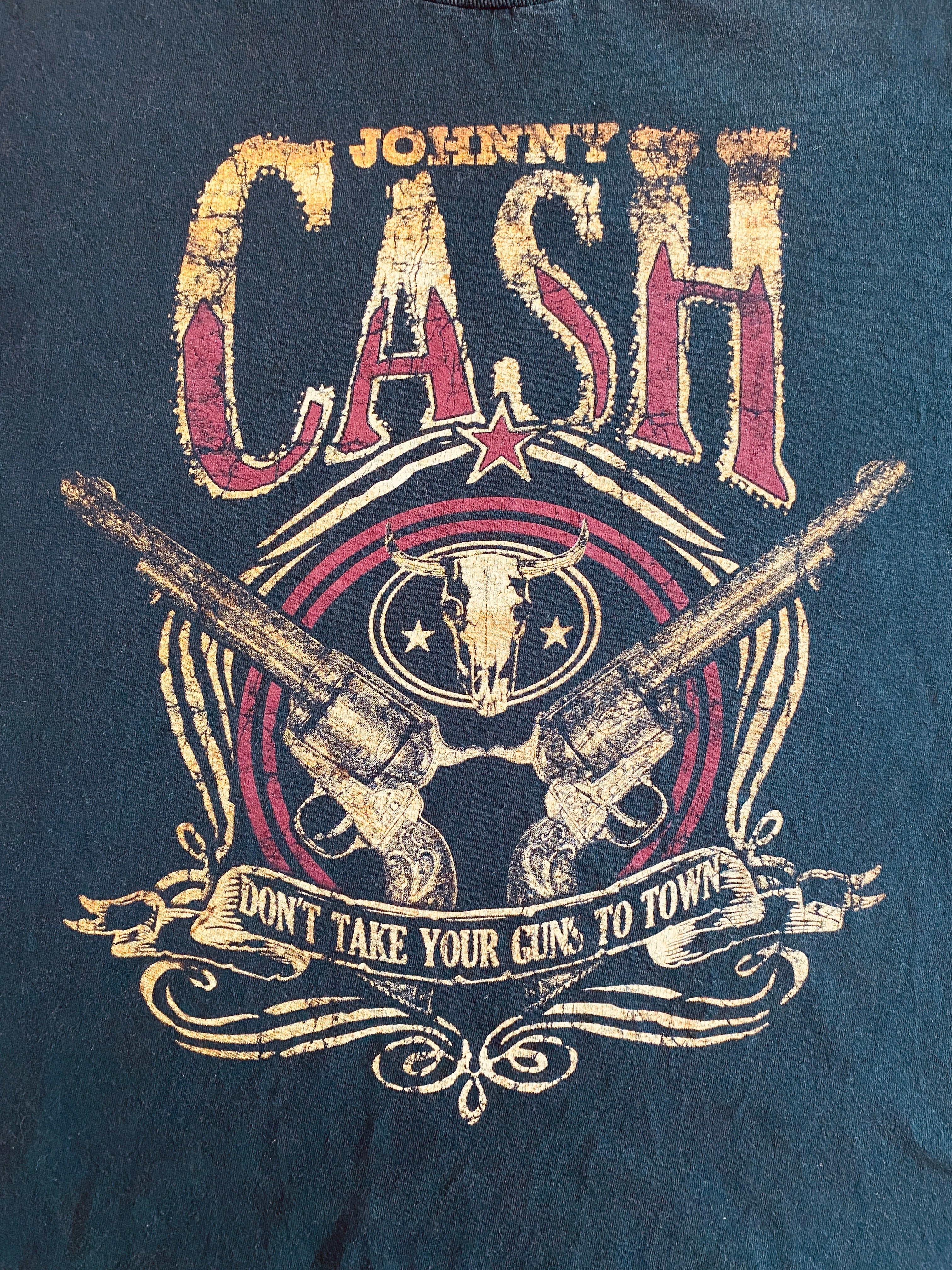 Détail flocage Johnny Cash – revolvers croisés, banderole et lettrage doré – style worn & washed