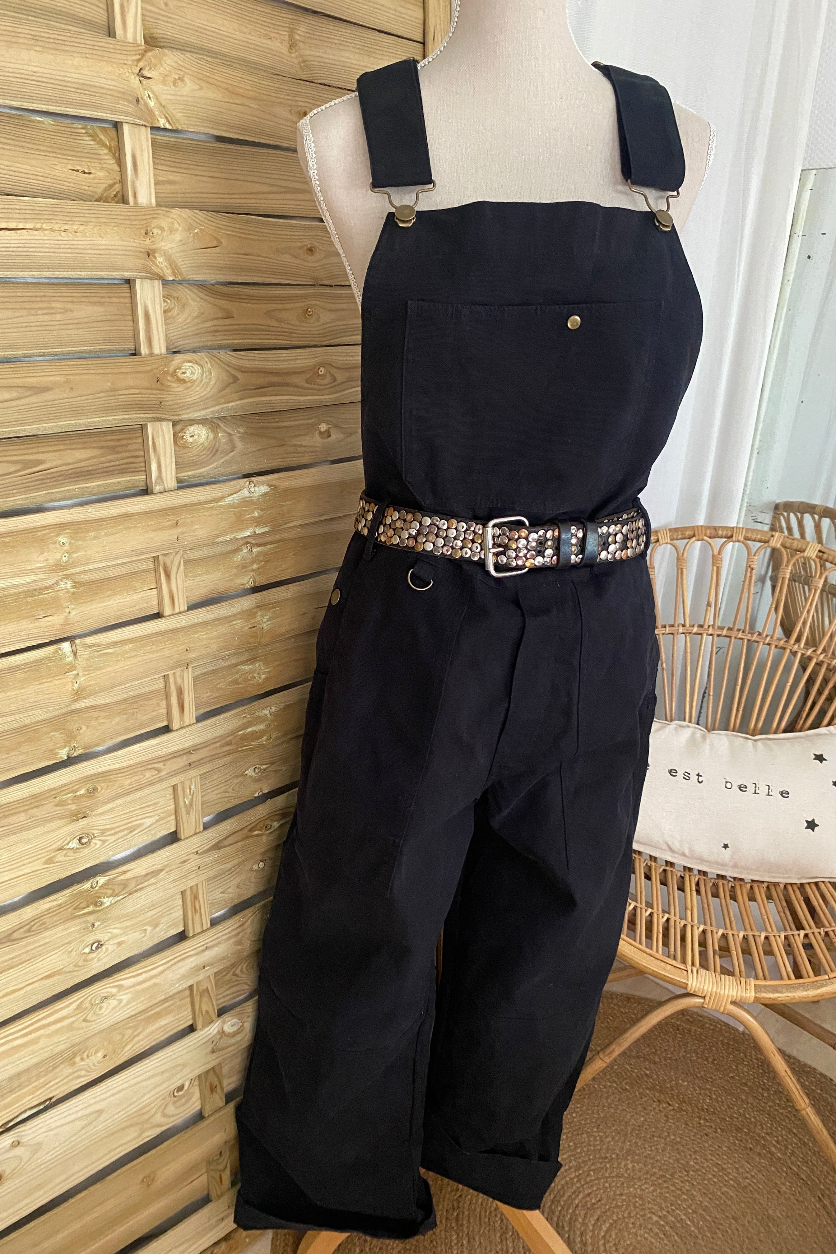 Salopette workwear SÜK denim brut noir portée sur buste de face, stylisée avec une ceinture à rivets argentés (pour inspiration)