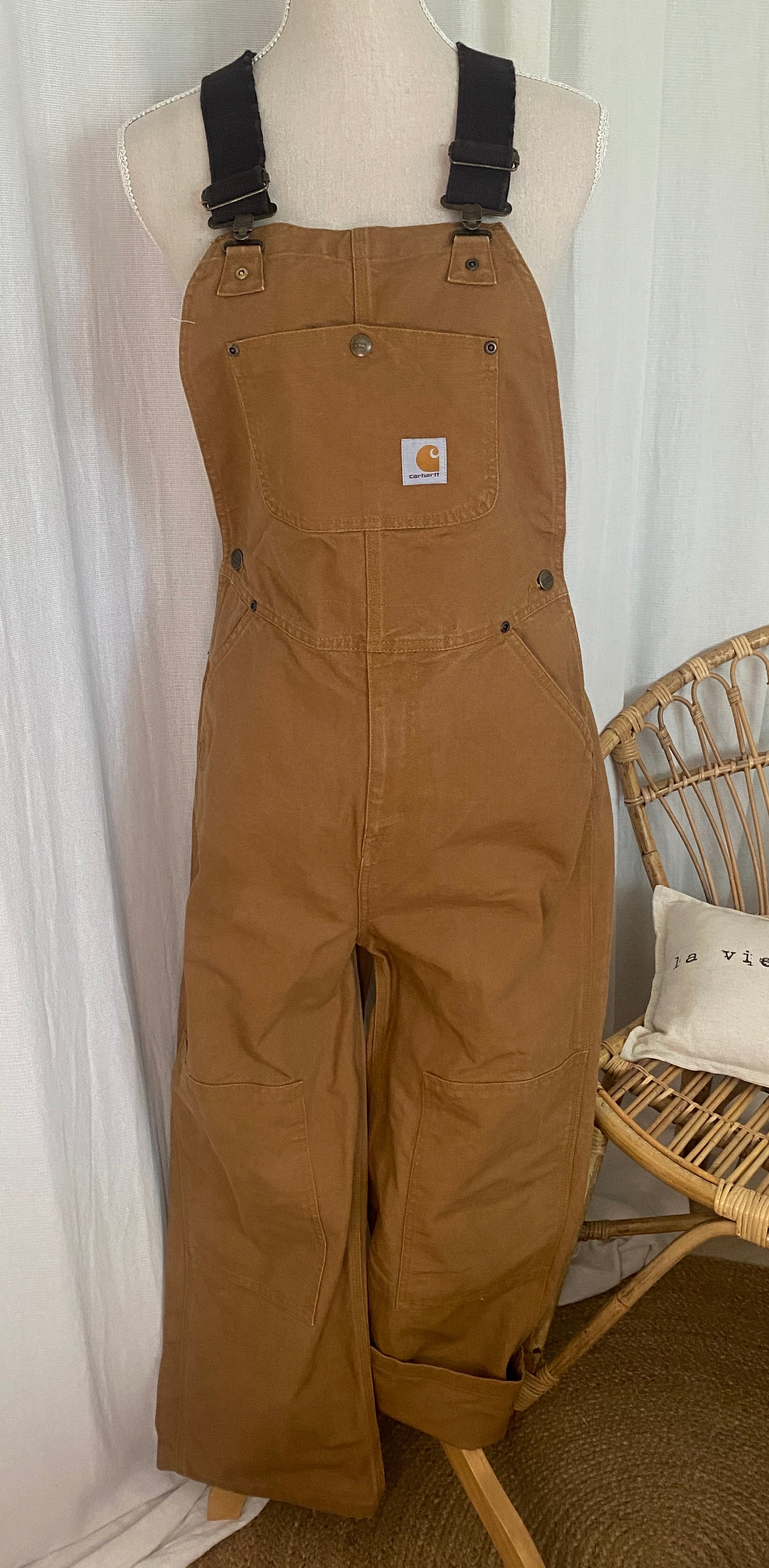 Salopette workwear Carhartt Duck Brown portée sur buste de face, coupe large et tablier avec patch logo woven
