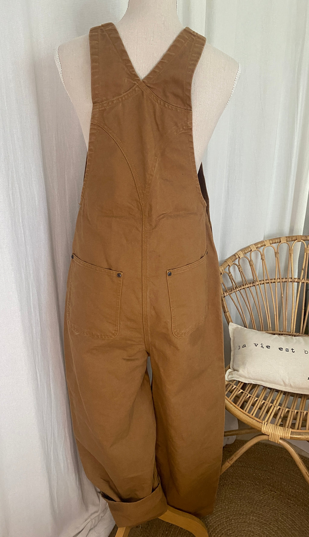 Étiquette intérieure Carhartt : Salopette workwear Carhartt Duck Brown vue de dos sur buste, bretelles marron foncé réglables et construction robuste