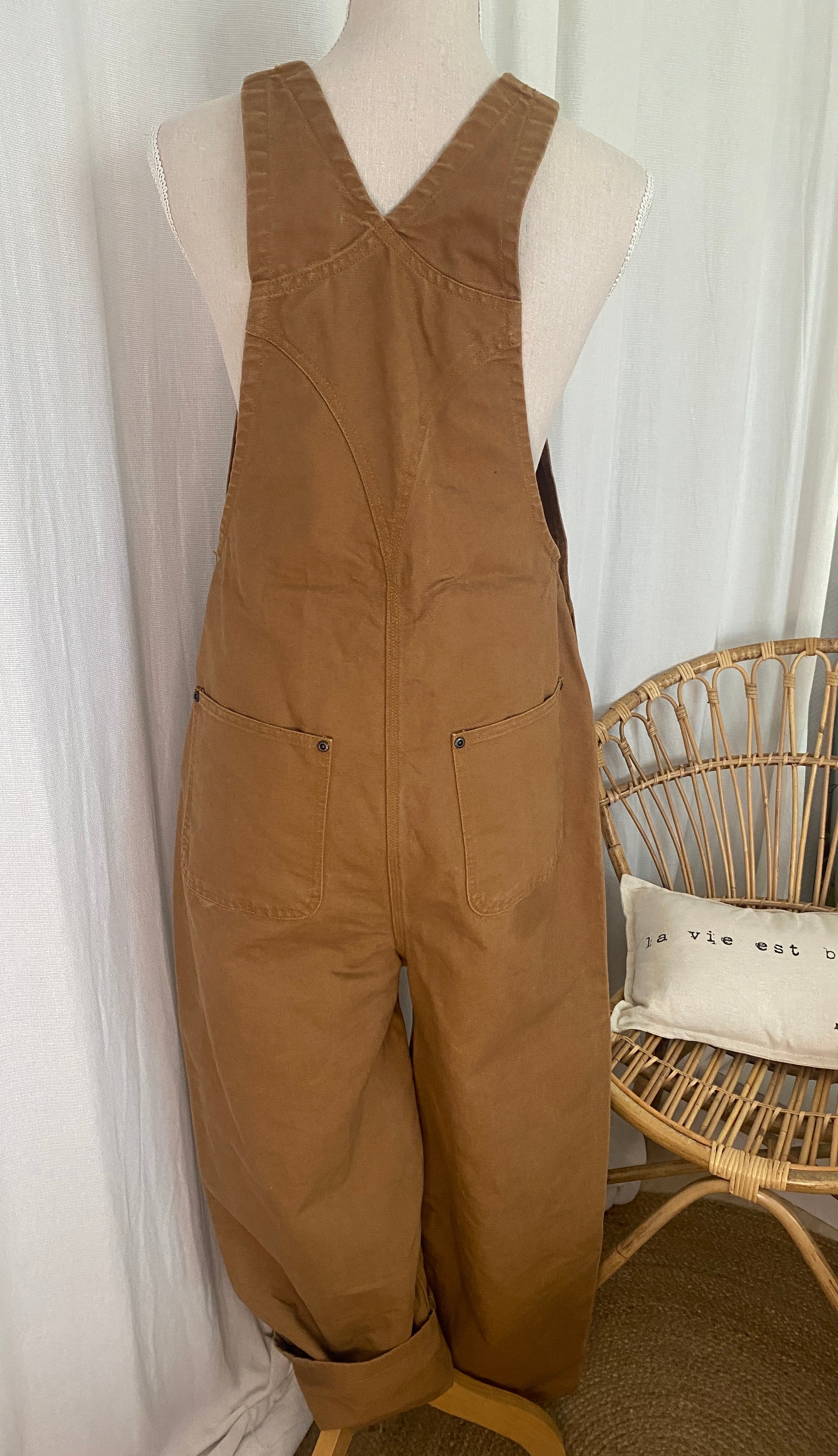 Étiquette intérieure Carhartt : Salopette workwear Carhartt Duck Brown vue de dos sur buste, bretelles marron foncé réglables et construction robuste