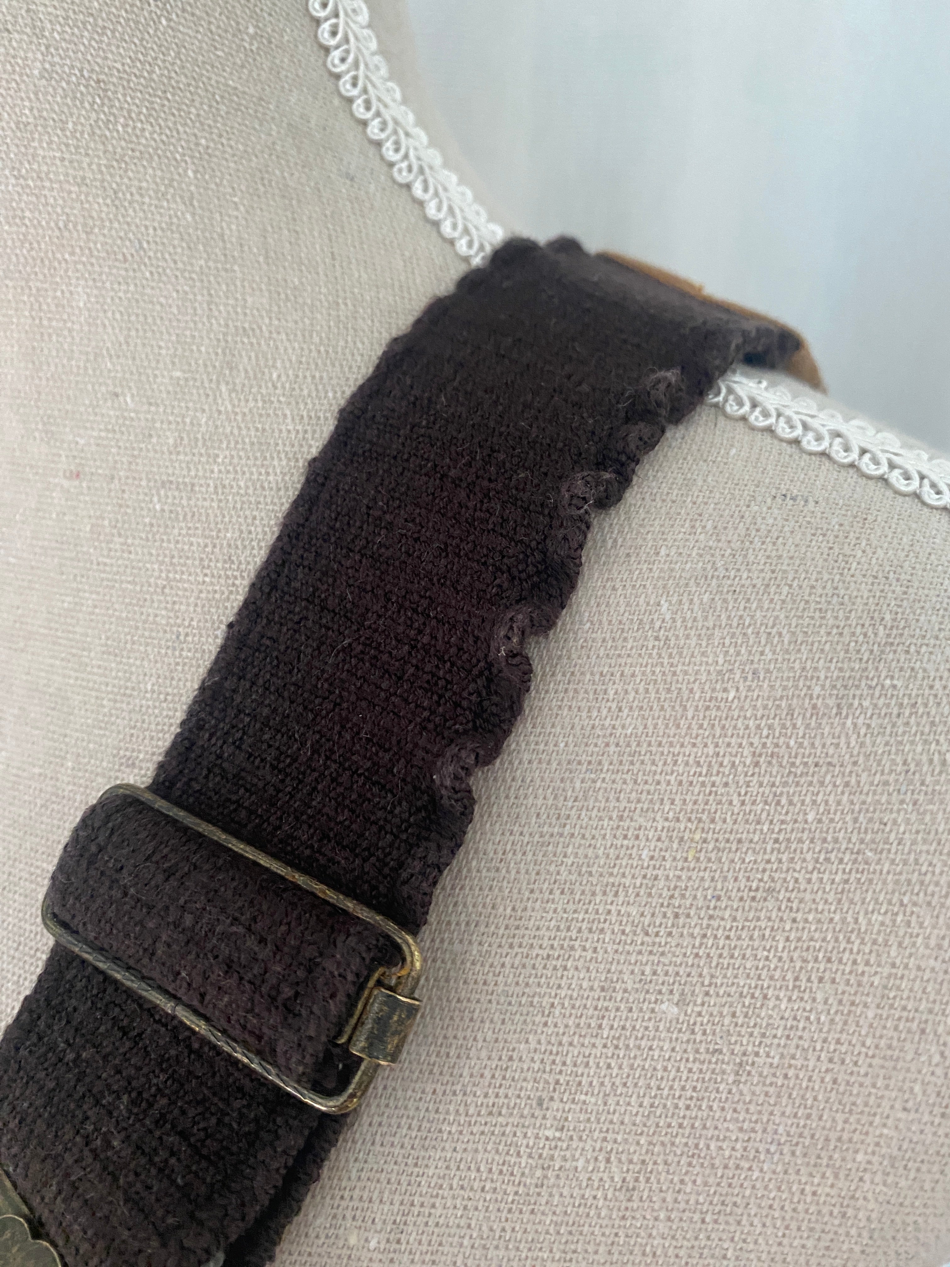 Détail bretelle élastique marron foncé légèrement gondolée sur la gauche — défaut mentionné, n'affecte pas le port