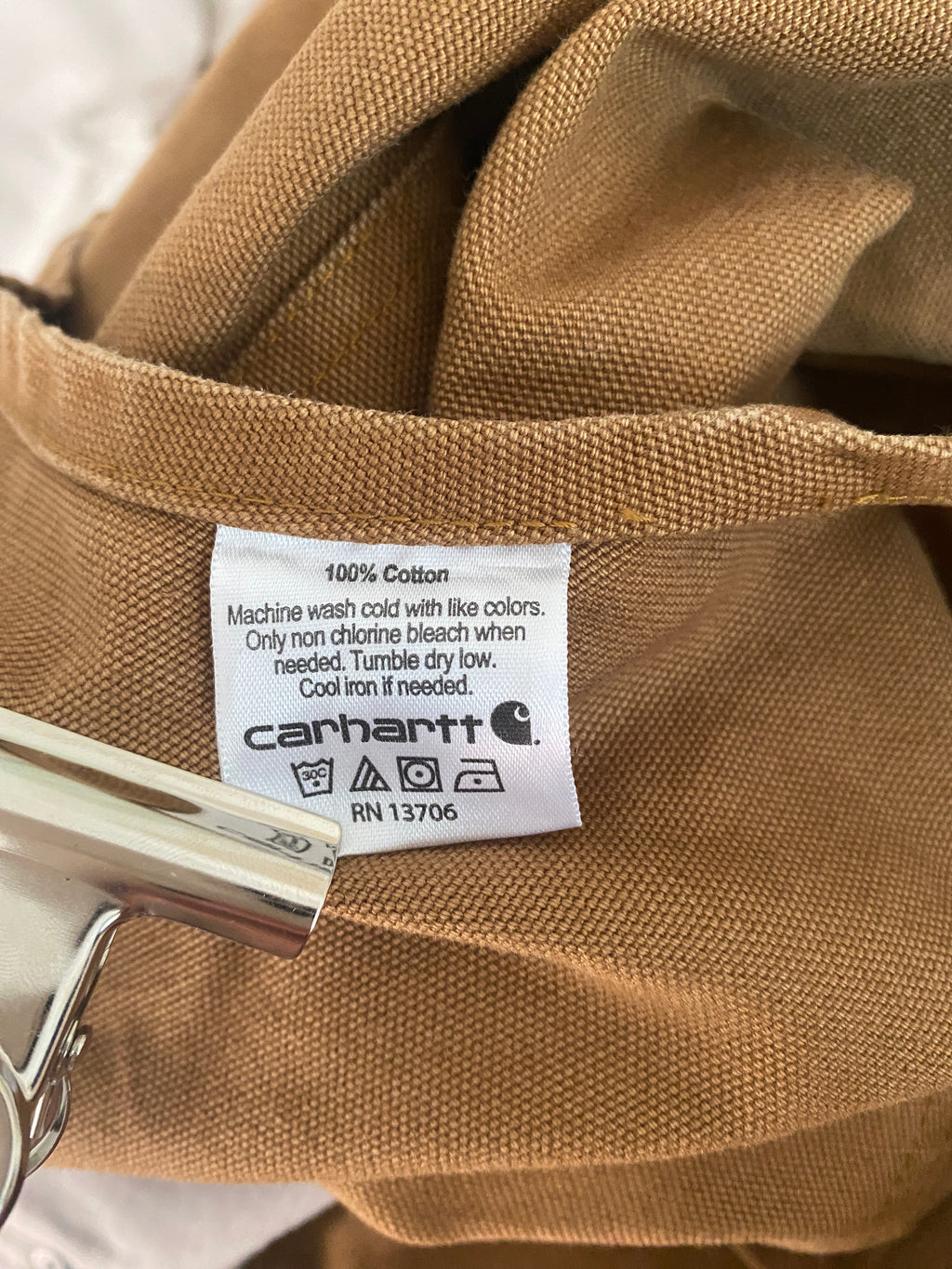 Étiquette intérieure Carhartt : composition 100% coton, instructions de lavage et référence RN 13706
