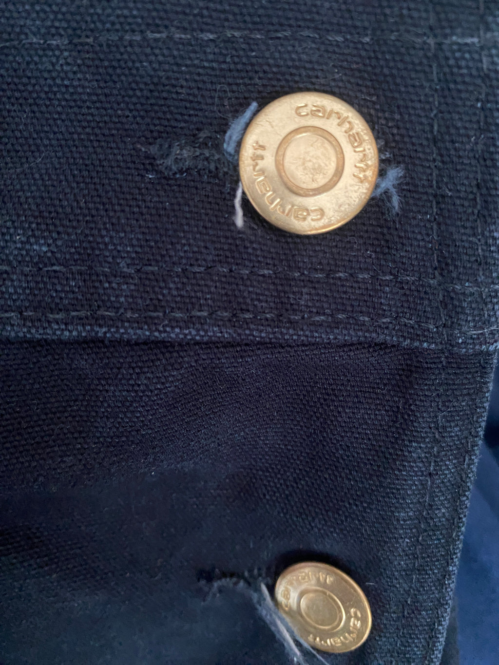 Détail boutons gravés Carhartt – hardware doré patiné salopette workwear noire