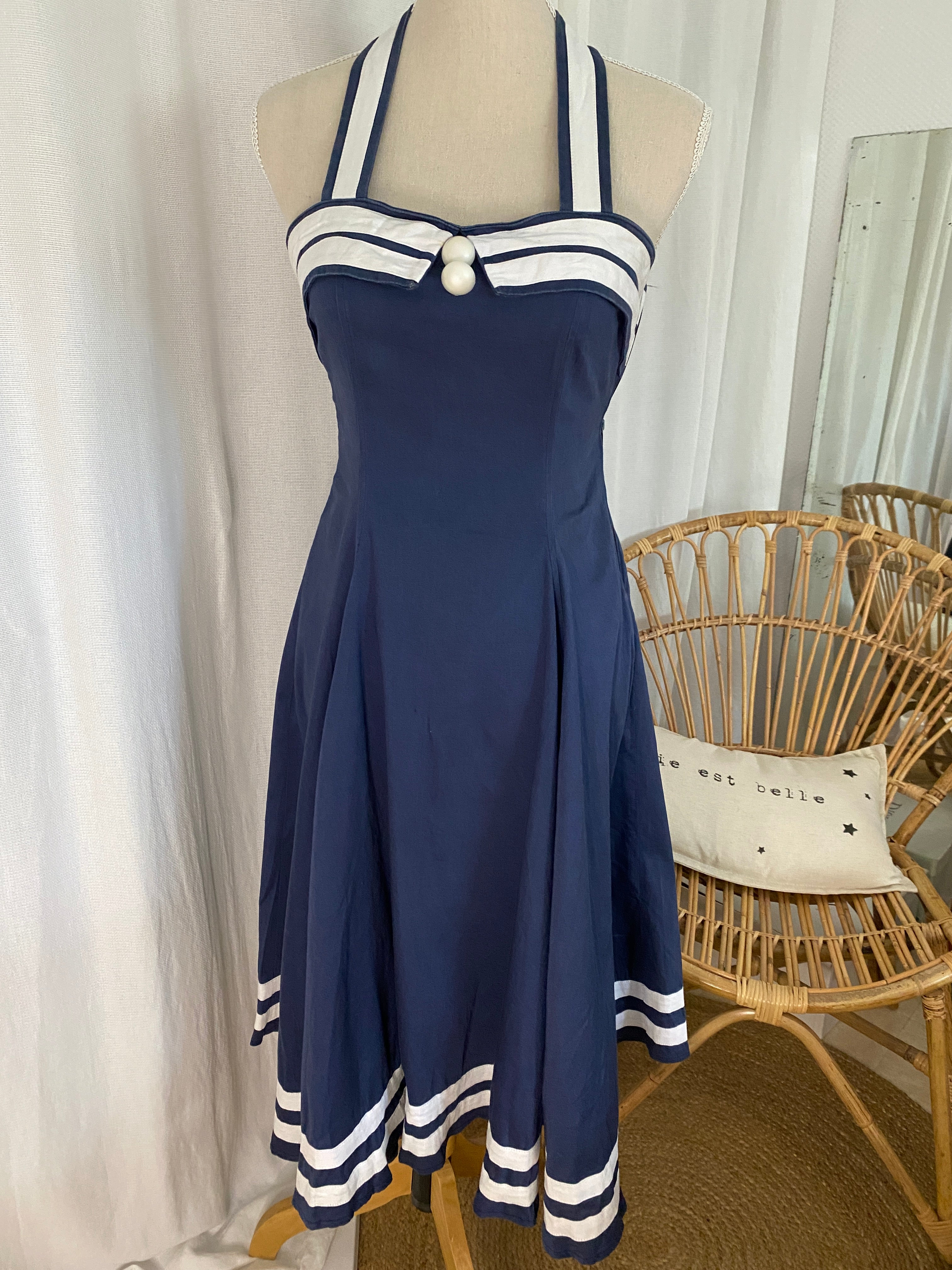 Robe pin up sailor Collectif bleu marine et blanc, coupe ajustée, décolleté sweetheart, nœud halter rayé, portée sur buste