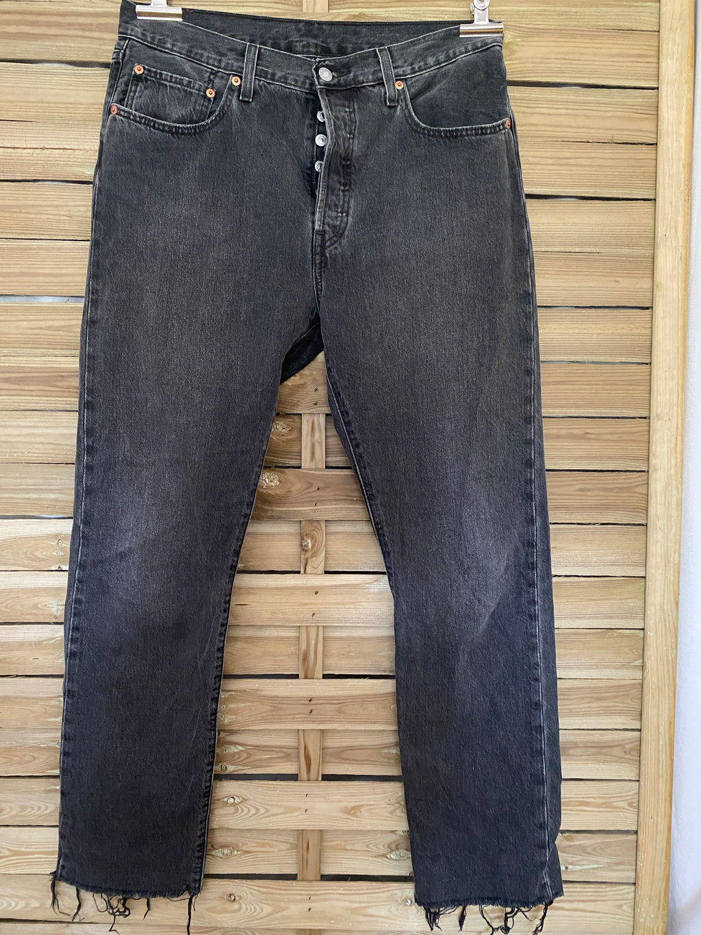Jean vintage Levi's 501 noir délavé – vue de face globale sur cintre